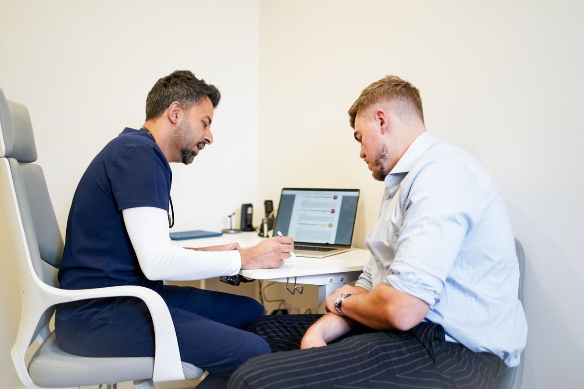 A GP discussing blood test results with a male patient at The Doctors Practice, Edgbaston
